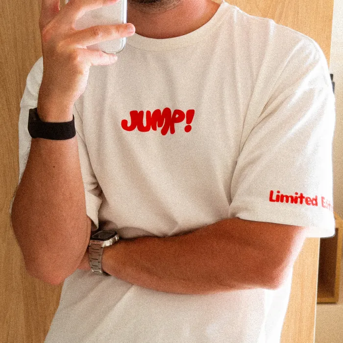 A mirror selfie in the white shirt, phone in hand: Jump! across the chest and “Limited Edition” on the sleeve, both in red
